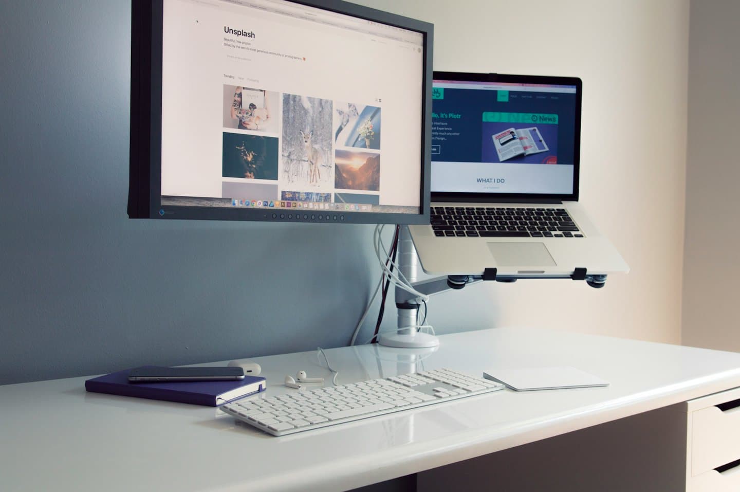 Home Una scrivania ordinata con doppio monitor e supporto per laptop.