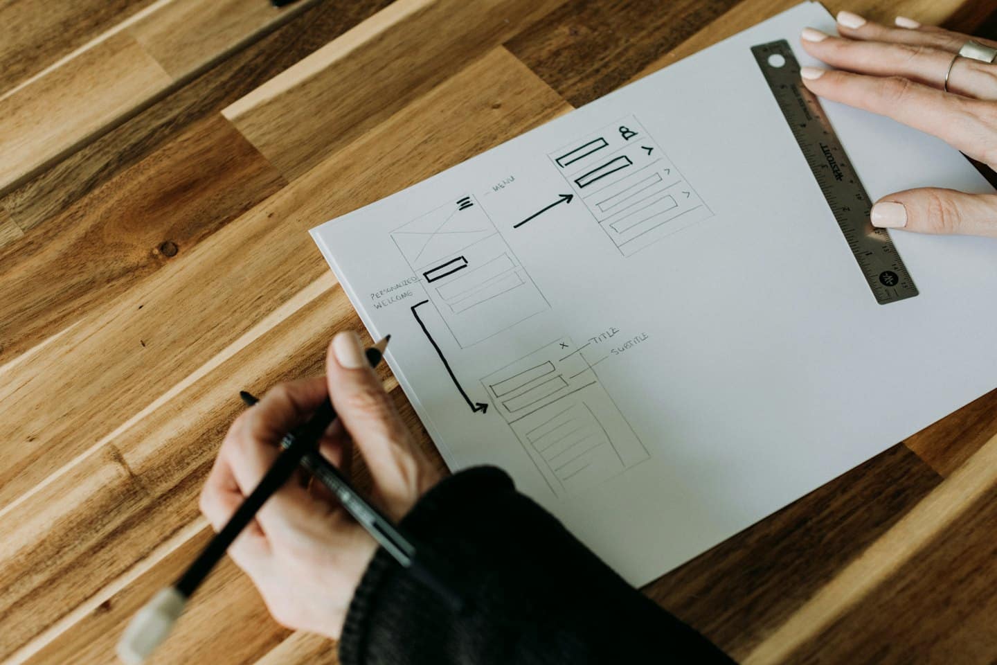 Home Mani che disegnano wireframe ed elementi di interfaccia utente su carta.